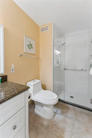 a bathroom with a granite countertop sink toilet and shower