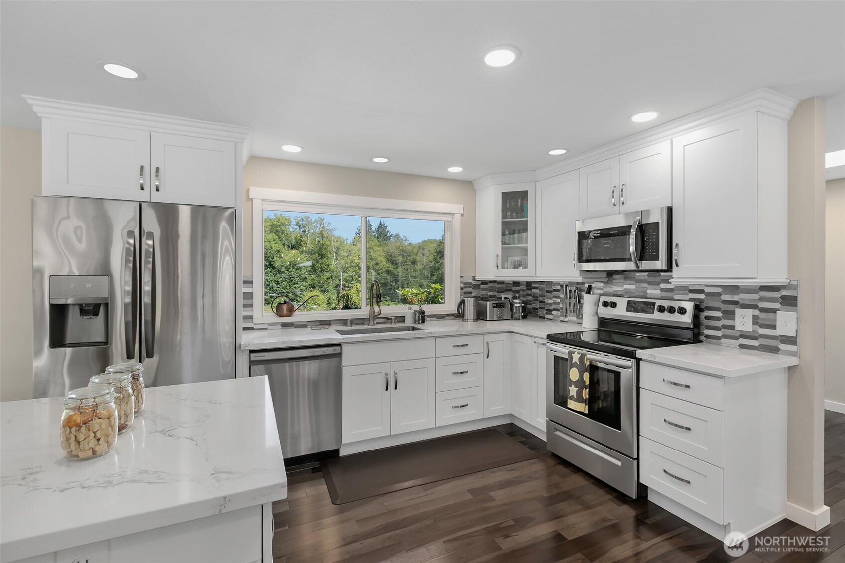 971 Sandy Point Road Langley, WA 98260 - Photo 6 of 35 a kitchen with stainless steel appliances white cabinets a sink a stove a refrigerator and island