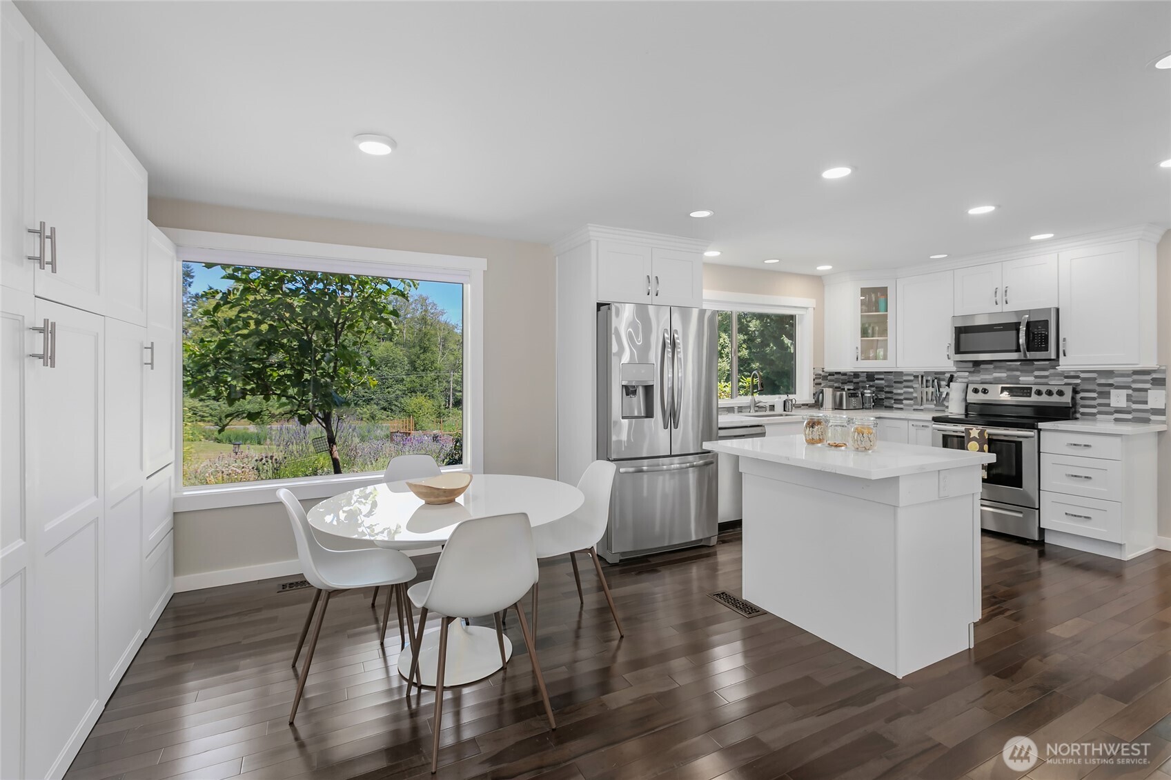 971 Sandy Point Road Langley, WA 98260 - Photo 7 of 35 a kitchen with kitchen island wooden cabinets and dining table