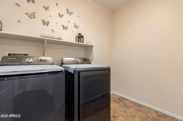 a utility room with cabinets washer and dryer