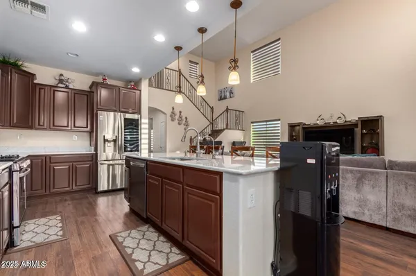 a kitchen with stainless steel appliances granite countertop a sink a stove and a refrigerator