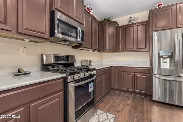 a kitchen with granite countertop wooden cabinets stainless steel appliances and a counter space