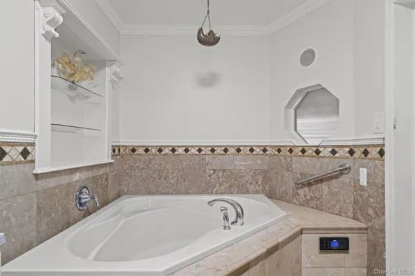 a bathroom with a tub sink and mirror