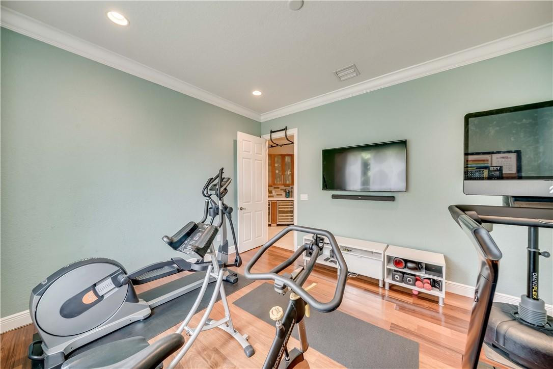 10508 Laurel Road Davie, FL 33328 - Photo 19 of 82 a room with gym equipment and a flat screen tv