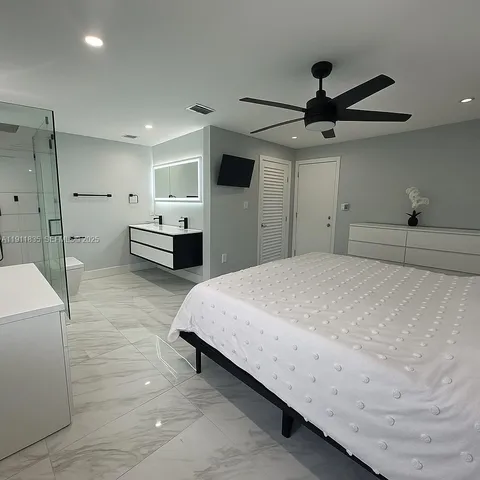 a spacious bedroom with a bed and a chandelier