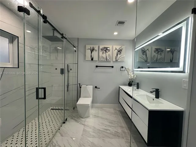 a bathroom with a sink mirror and toilet