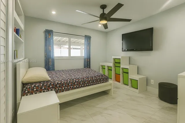 a bedroom with a bed a flat screen tv and a couch