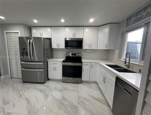 a kitchen with a refrigerator sink and cabinets