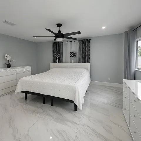 a bed room with a bed and a ceiling fan