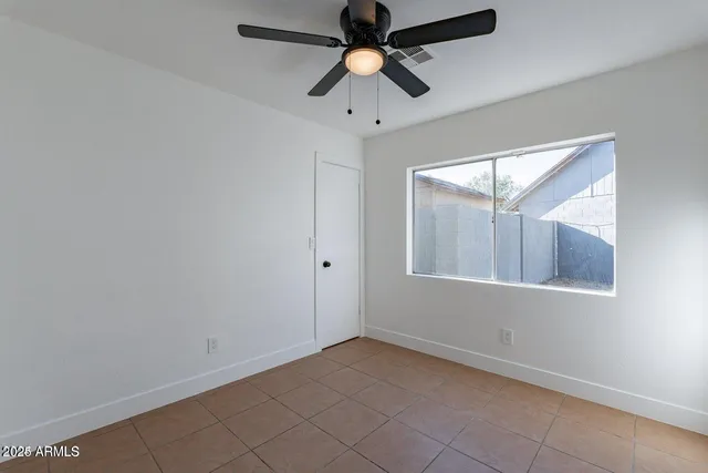 an empty room with chandelier fan