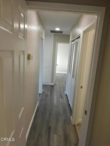 a view of a hallway with wooden floor