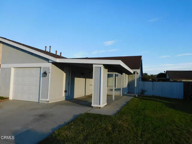 a backyard of a house with table and chairs