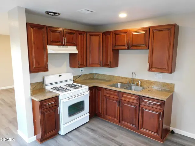 a kitchen with stainless steel appliances granite countertop a stove sink and cabinets