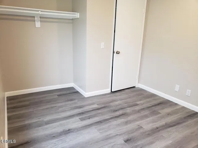 a view of an empty walk in closet with wooden floor