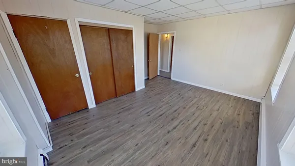 an empty room with wooden floor and stairs