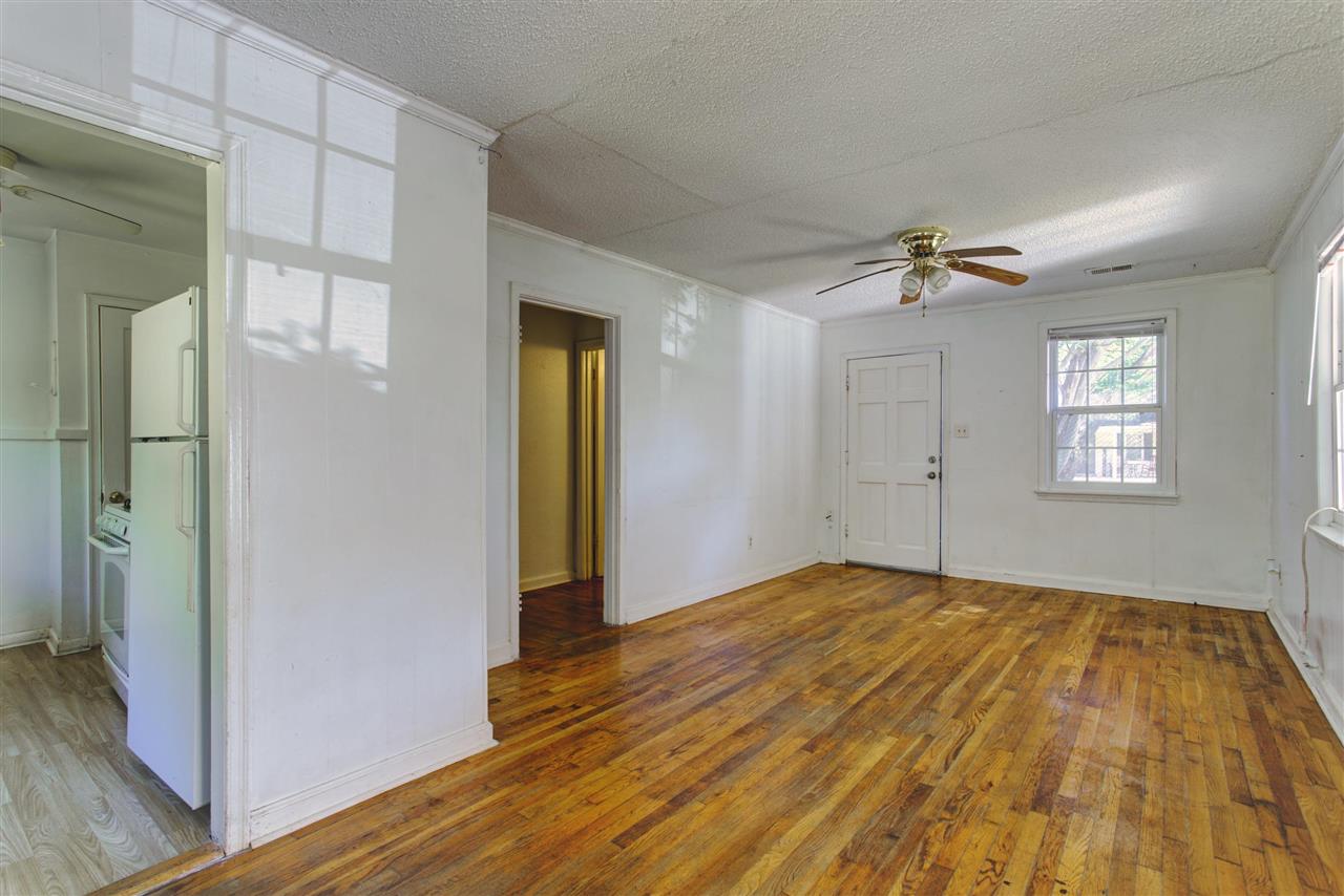 903 Tatum Road Memphis, TN 38122 - Photo 3 of 10 a view of an empty room with wooden floor and a window