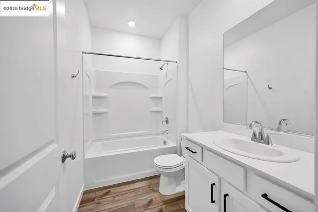 a bathroom with a granite countertop toilet a sink and a bathtub