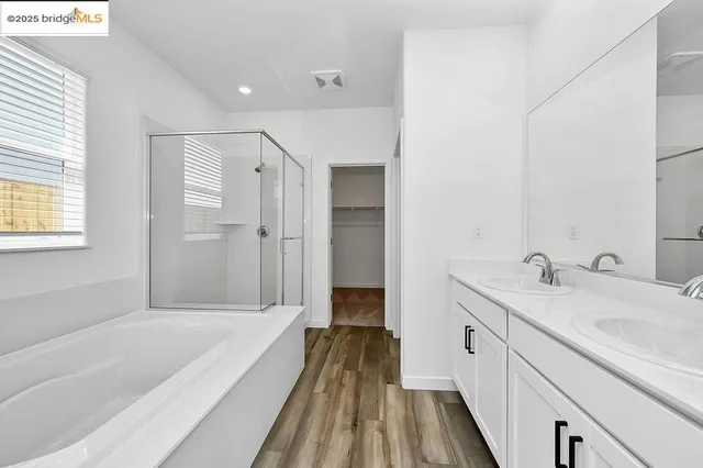 a spacious bathroom with a tub sink and mirror