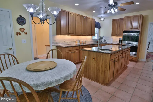 a kitchen with a table chairs sink and cabinets