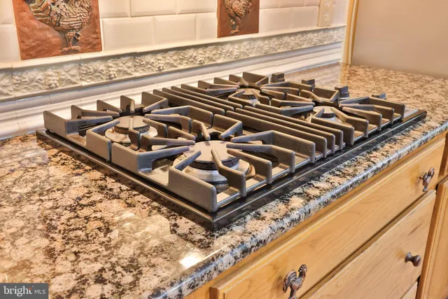 a kitchen with granite countertop a sink a stove and a wooden cabinets