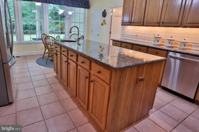 a kitchen with stainless steel appliances granite countertop a sink and wooden cabinets