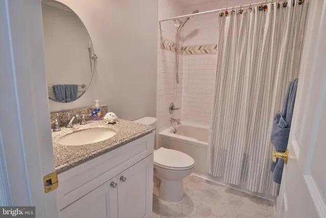 a bathroom with a granite countertop sink a toilet and a mirror