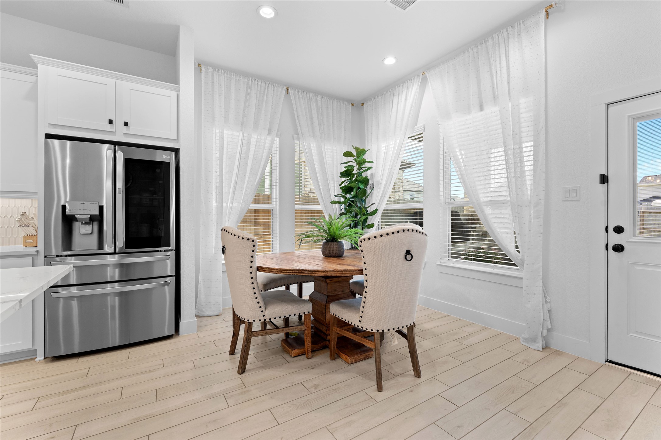 17735 Tree Of Heaven Conroe, TX 77385 - Photo 11 of 35 a kitchen with stainless steel appliances a dining table chairs and refrigerator