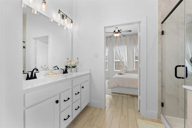 a en suite bathroom with a double vanity sink a mirror and a shower