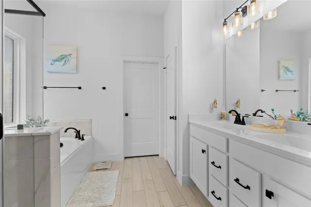 a bathroom with a double vanity sink a mirror and next to a window