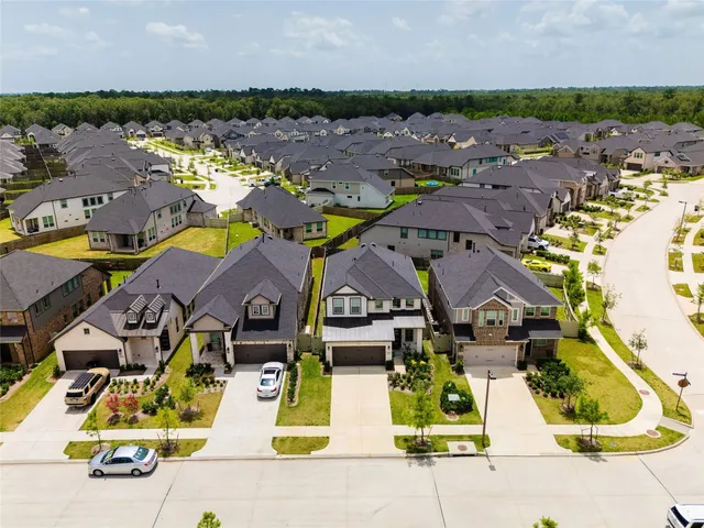 an aerial view of residential houses with outdoor space and lake view