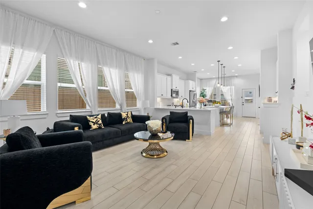 a living room with furniture wooden floor and a large window