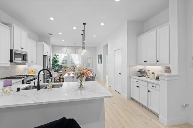 a kitchen with kitchen island a sink stainless steel appliances and cabinets