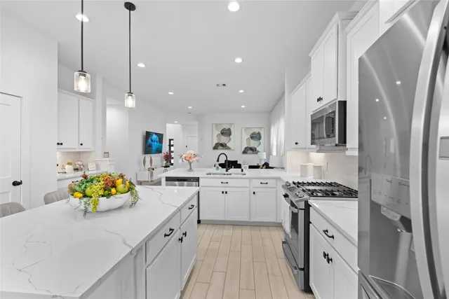 a kitchen with stainless steel appliances granite countertop a sink a stove and cabinets