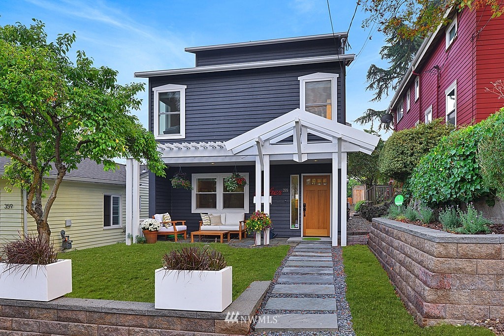a front view of a house with a yard and potted plants