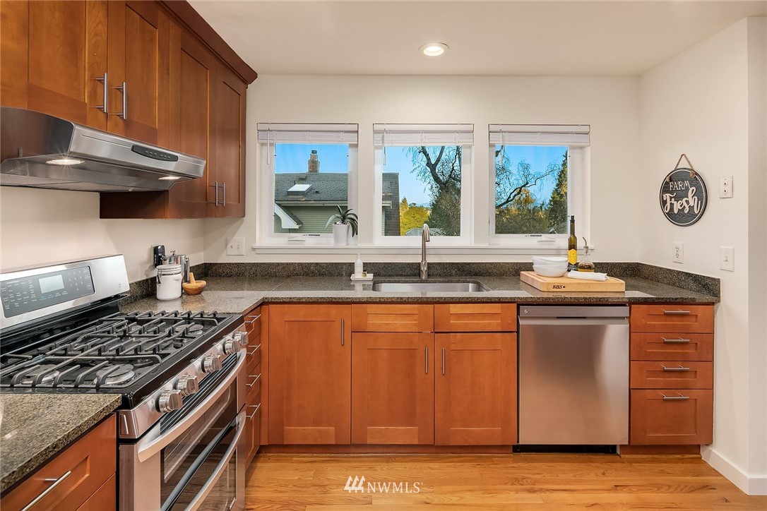 355 North 75th Street Seattle, WA 98103 - Photo 12 of 32 a kitchen with stainless steel appliances granite countertop a stove and a sink