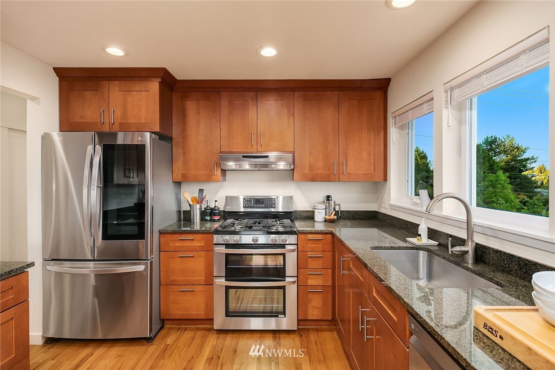 355 North 75th Street Seattle, WA 98103 - Photo 13 of 32 a kitchen with stainless steel appliances granite countertop a refrigerator stove and sink