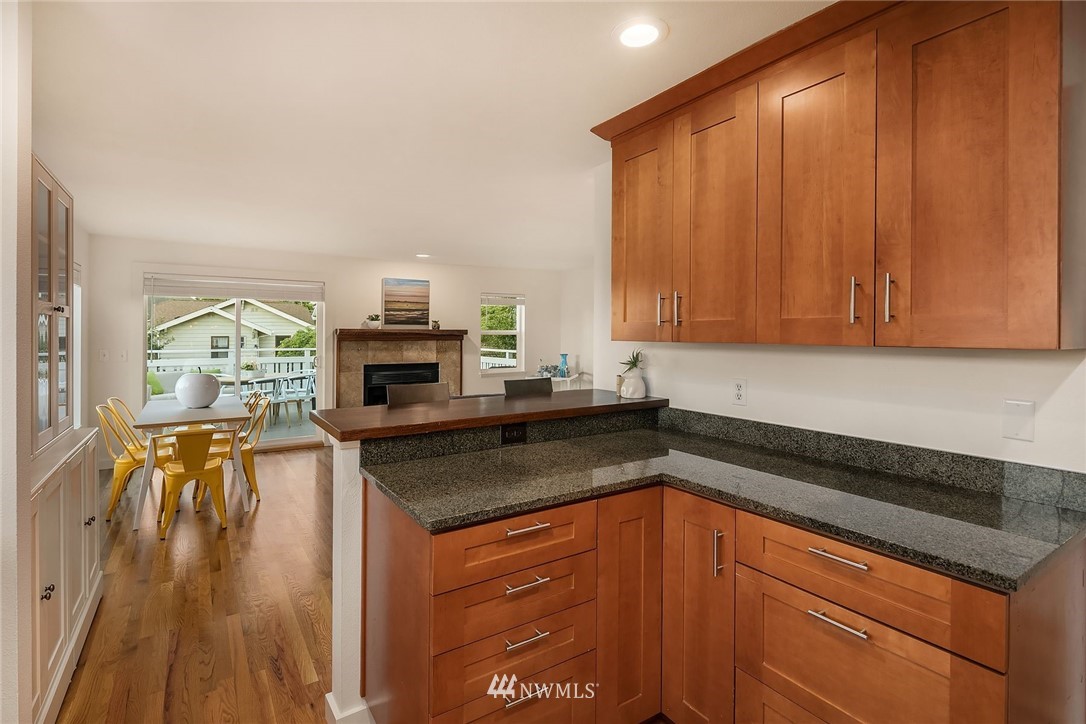 355 North 75th Street Seattle, WA 98103 - Photo 15 of 32 a kitchen with granite countertop stainless steel appliances a stove a sink and a microwave