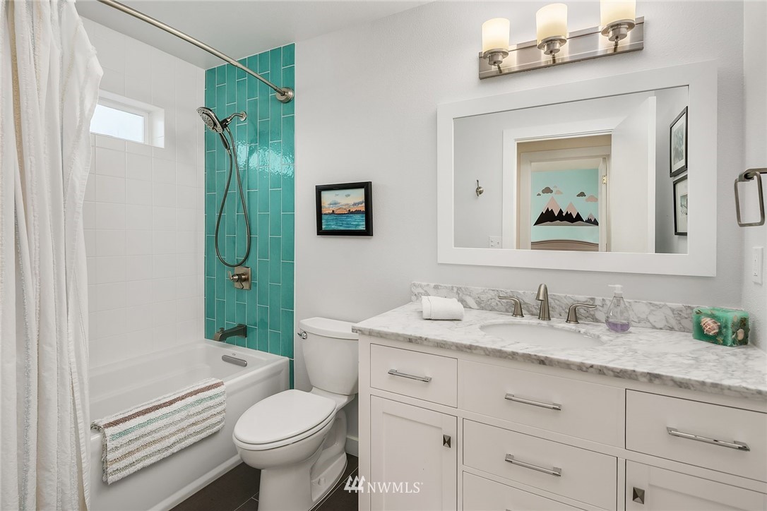 355 North 75th Street Seattle, WA 98103 - Photo 17 of 32 a bathroom with a granite countertop toilet sink and mirror