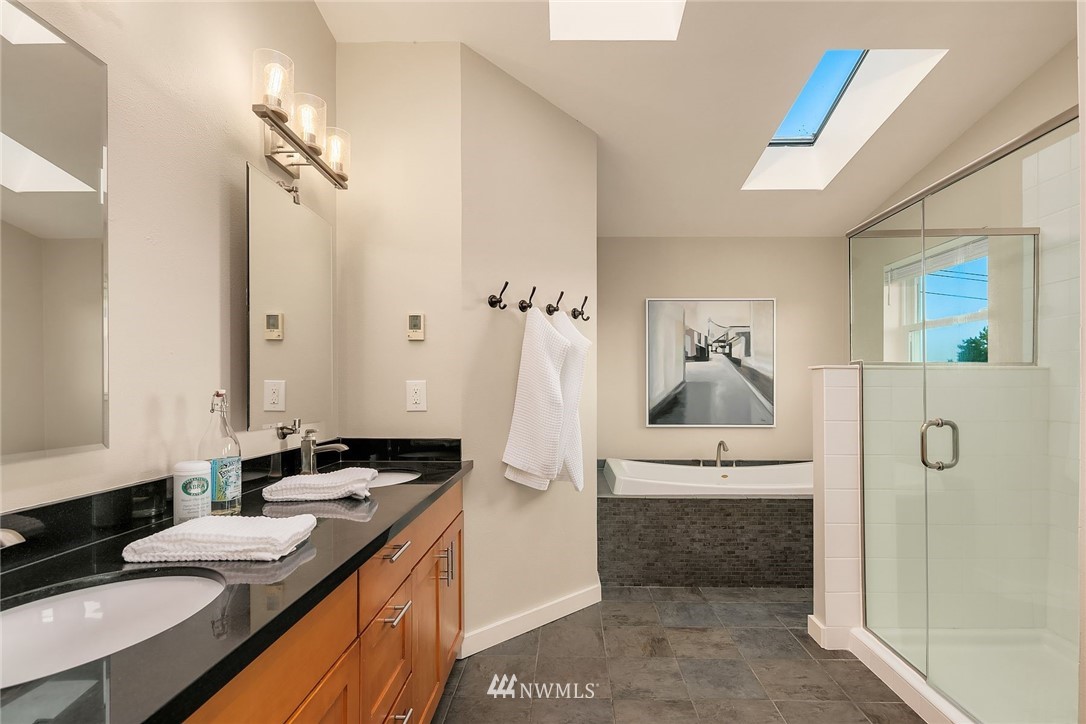 355 North 75th Street Seattle, WA 98103 - Photo 23 of 32 a spacious bathroom with a granite countertop sink and a mirror