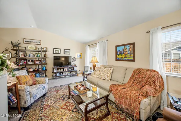 a living room with furniture a flat screen tv and a window