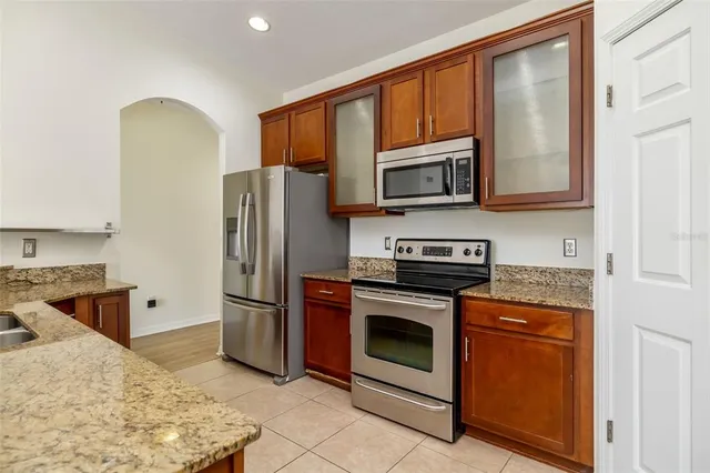 a kitchen with stainless steel appliances granite countertop a stove a refrigerator and a microwave