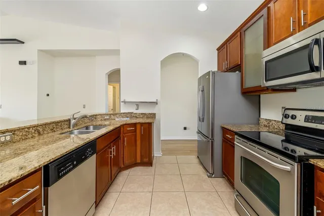 a kitchen with stainless steel appliances granite countertop a stove a sink and a microwave