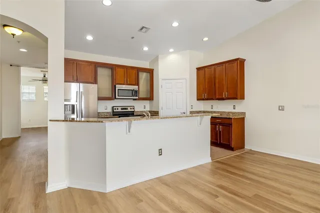 a kitchen with stainless steel appliances a stove top oven a sink a refrigerator and a microwave