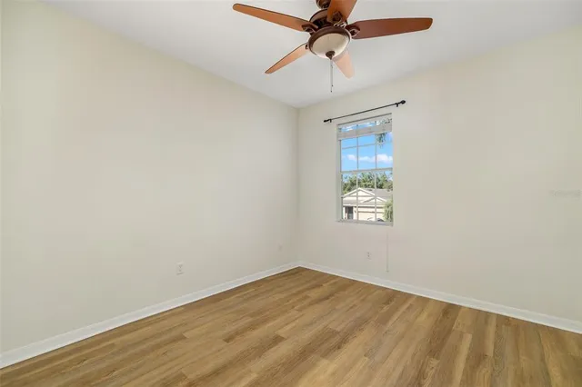 an empty room with a window and a fan