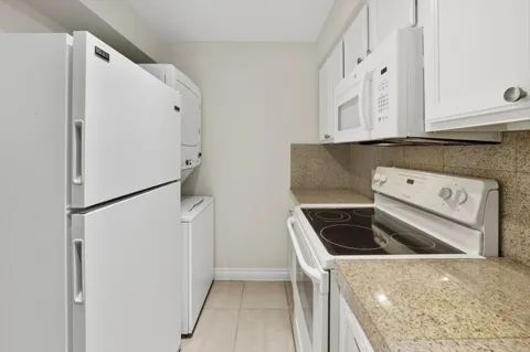 a kitchen with a refrigerator sink and cabinets