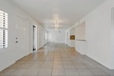 a big room with chandelier fan and windows
