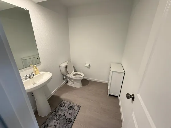 a bathroom with a toilet a sink and a mirror