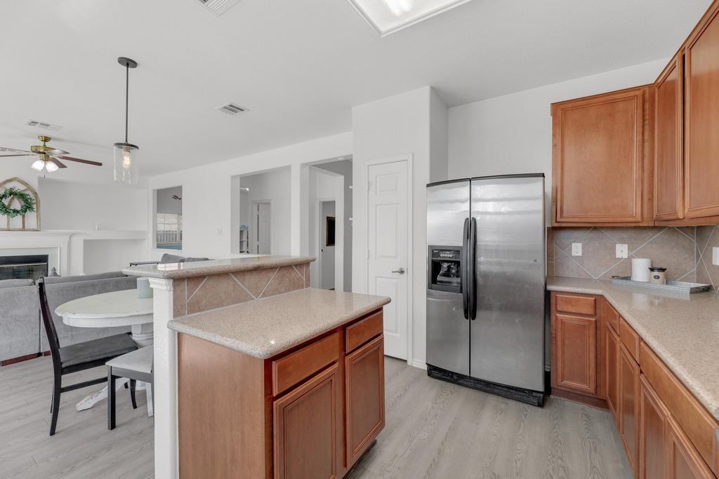 150 Mistletoe Lane Kyle, TX 78640 - Photo 35 of 35 a kitchen with refrigerator cabinets and wooden floor