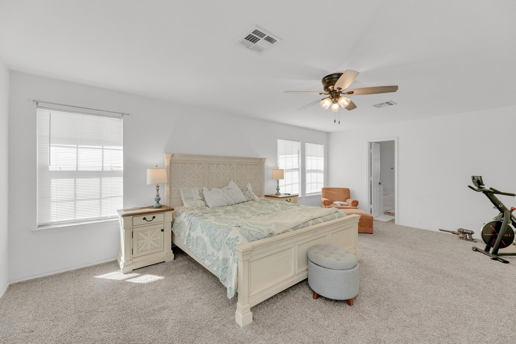 150 Mistletoe Lane Kyle, TX 78640 - Photo 13 of 35 a spacious bedroom with a bed and a chandelier