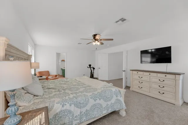 a spacious bedroom with a bed and a chandelier